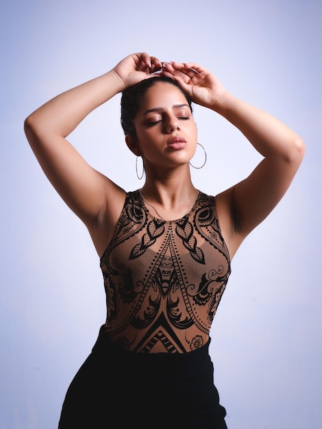 Elegant latin woman with closed eyes and raised arms