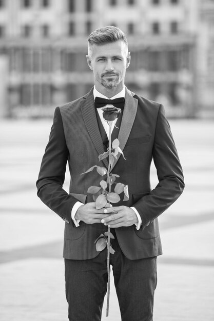 Photo elegant man in tuxedo at romantic occasion man with romantic present grizzle romantic man