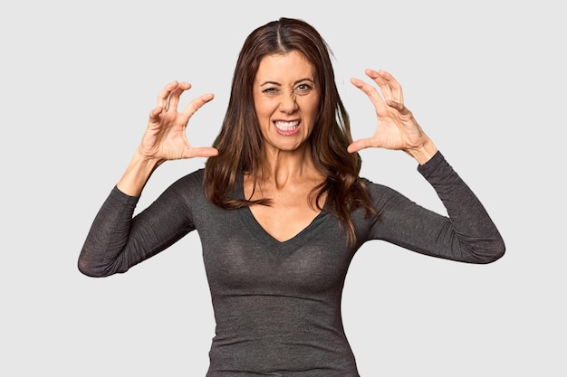 Elegant middleaged Caucasian woman in studio setting screaming with rage