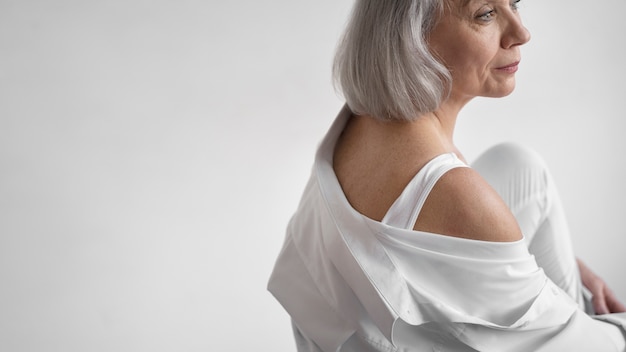 Elegant old woman wearing white clothes