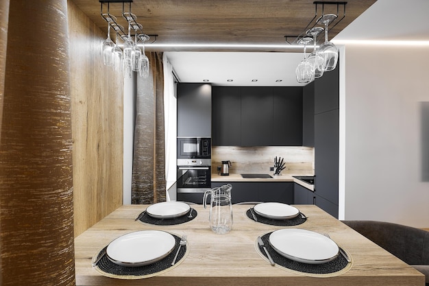 Elegant setting on wooden dining table in empty kitchen