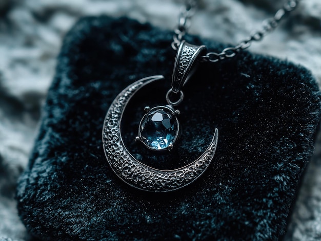 Photo elegant silver pendant with blue gemstone on dark fabric