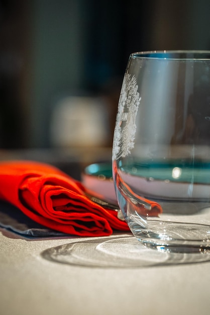 Elegant single wine glass on a table with a red cloth napkin beside it