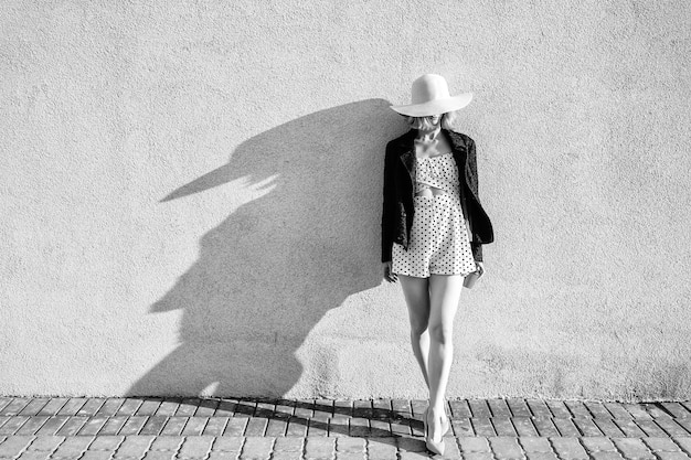 Elegant stylish blonde short hair girl in hat and dress posing with coffee over white