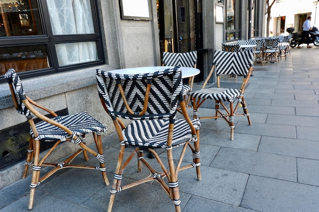 Elegant table and chairs outside on open classical terrace on the street in Madrid downtown Spain