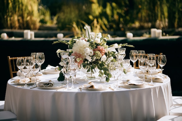 Photo elegant table set, table decoration at the wedding ceremony in the summer garden, catering service outdoor