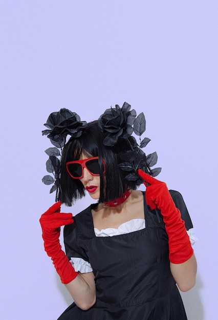 Elegant vampire gothic brunette Lady in red gloves holding black roses