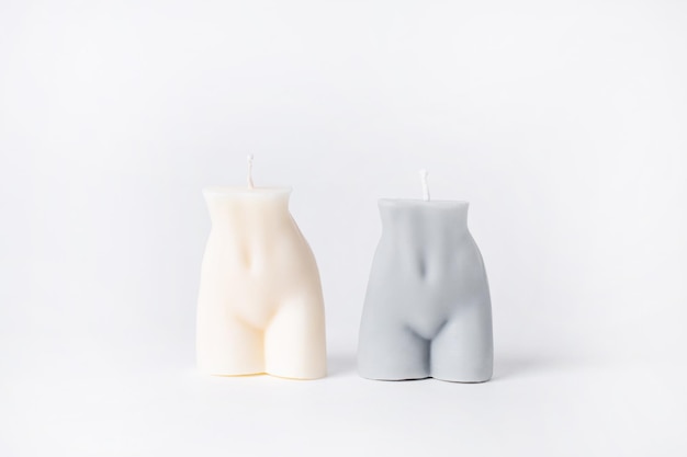 An elegant white soy candle in the shape of a male body on white background isolated