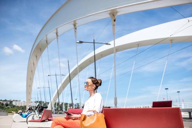 Photo elegant woman sitting on the modern bridge in lyon city