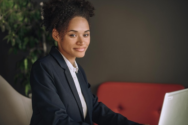 Elegant woman sitting in office smiling at camera