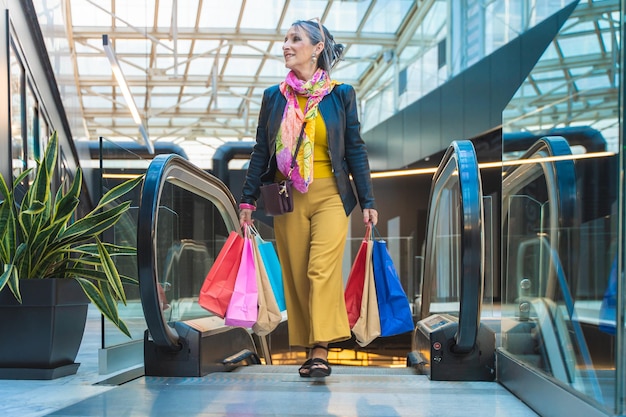 Elegant woman with colorful shopping bags in the mall before Christmas Holiday shopping sale