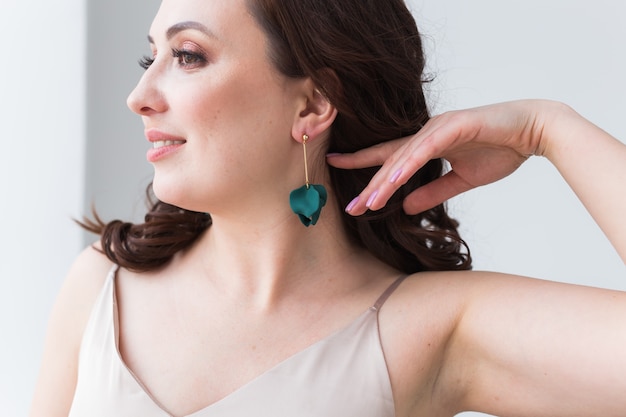 Elegant woman with earrings, close up portrait. Accessories, jewelry and bijouterie concept.