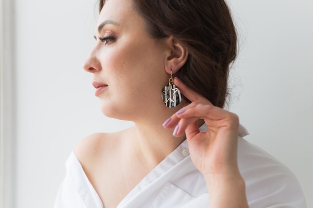 Elegant woman with earrings, close up portrait.