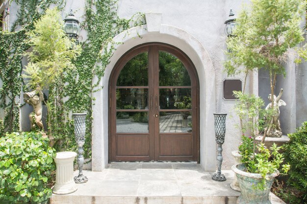 Elegant wooden front door surrounded by garden