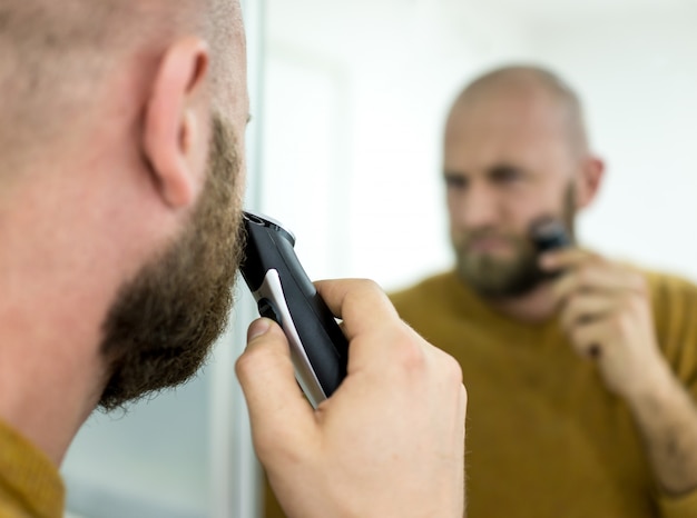 Elegant young handsome man making beard perfect