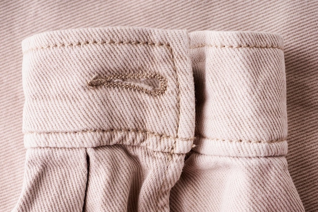 Elements of tailoring a denim beige shirt closeup Pockets buttons and sleeves on a denim shirt Modern comfortable denim clothing concept