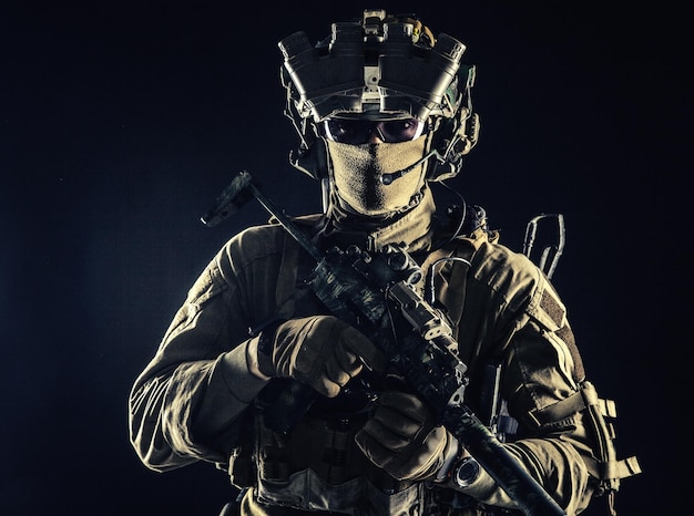 Elite commando fighter private military company mercenary special operations serviceman security or secret service shooter equipped modern weapons and ammunition studio shoot on black background