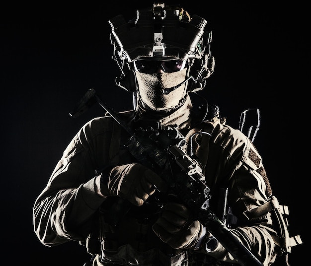 Elite commando fighter private military company mercenary special operations serviceman security or secret service shooter equipped modern weapons and ammunition studio shoot on black background