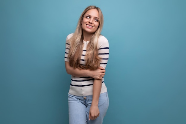 Embarrassed girl in casual clothes posing on a blue isolated background