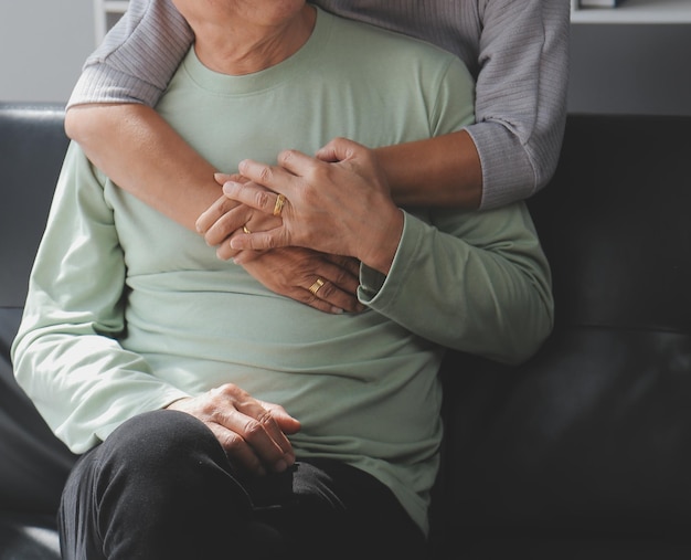 Embraced mature couple surfing the Internet on laptop at home