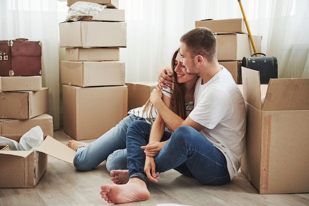 Embracing each other. Cheerful young couple in their new apartment. Conception of moving.