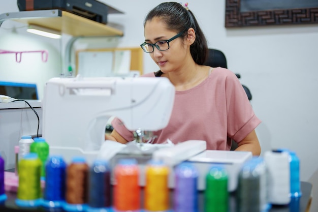 Embroidery handicrafts hobbies SME business family business Portrait of Asian female designers are doing by designing patterns using automatic embroidery machines by customer order