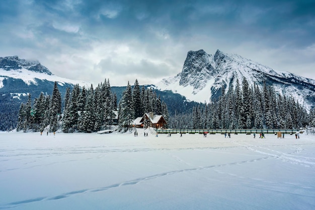 Emerald Lake with wooden lodge glowing in snowy pine forest and rocky mountains on winter at Yoho national park