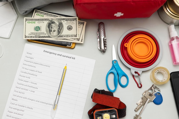 Emergency backpack equipment organized on the table Documents waterfood first aid kit and another items needed to survive