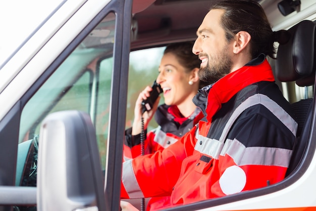 Emergency doctor and nurse driving ambulance