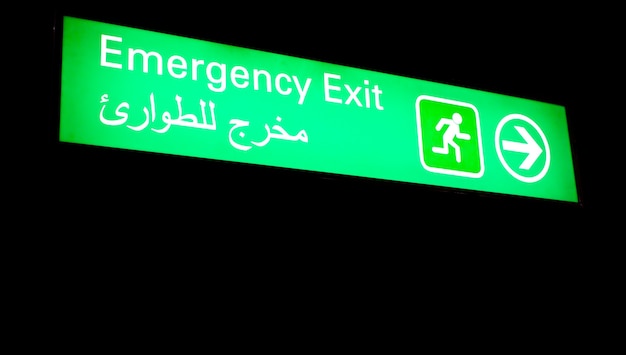 Emergency exit sign in an international airport in Middle East with Arabic information