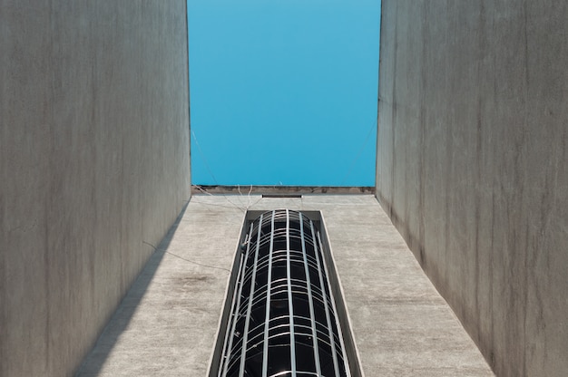 Emergency fire escape staircases on a building exterior with blue sky above