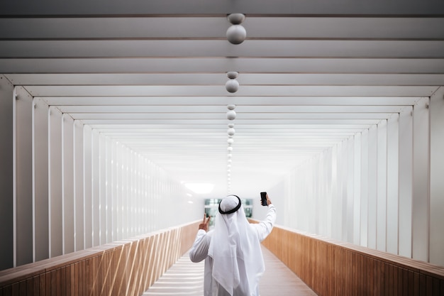 Emirati guy taking selfie in the urban city lifestyle downtown the heart of Dubai.