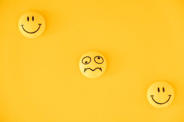 Emoticon icons funny faces on yellow background. Minimal concept. Top view. Copy, empty space for text