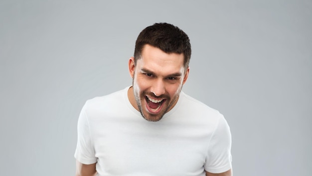 emotion, cruelty, anger and people concept - angry man over gray background