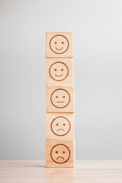 Emotion face symbol on wooden blocks Service rating ranking customer review satisfaction evaluation and feedback concept