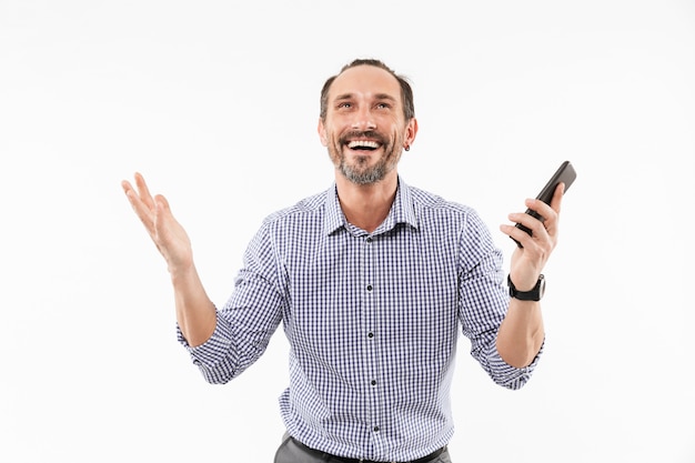 Emotional adult man using mobile phone.