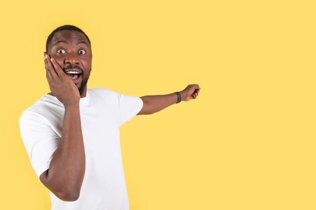 Emotional African American Man Pointing Finger Aside Over Yellow Background