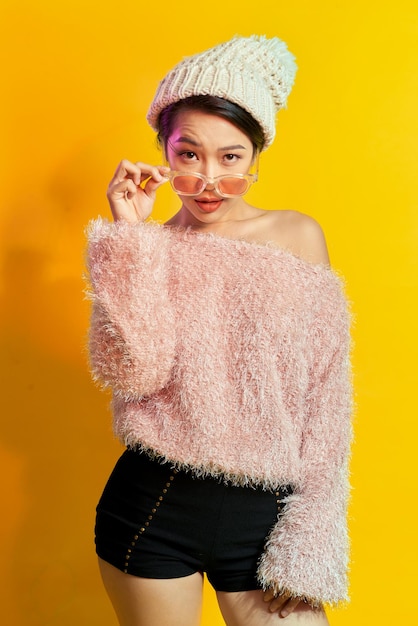 Emotional asian girl with eyeglasses Indoor photo of amazed woman in trendy fur coat