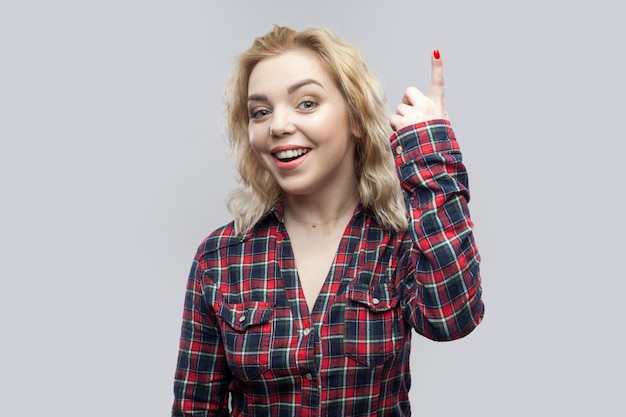 Emotional blonde young woman on gray background