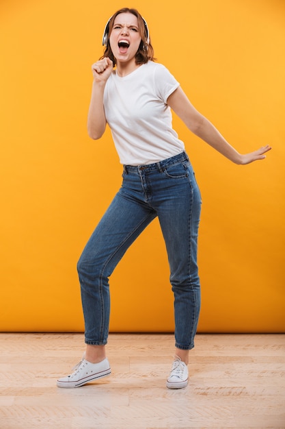 Photo emotional funny young woman listening music singing.