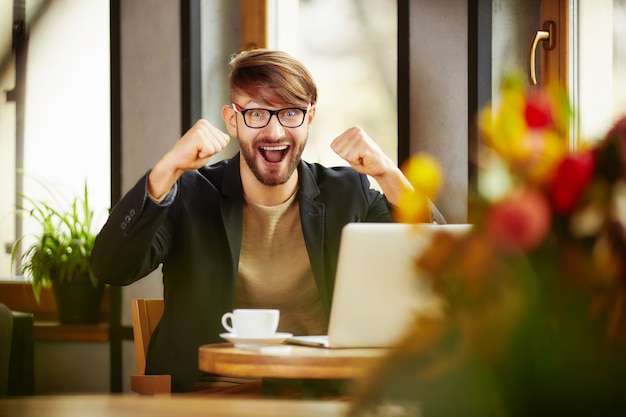 Emotional man celebrating at laptop