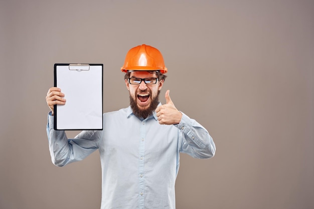 Emotional man wearing orange hard hat on industry documents