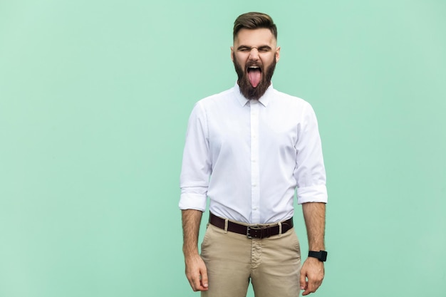 Emotional man in white shirt near green background