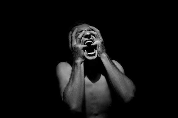 Emotional photo, man shouting on black background