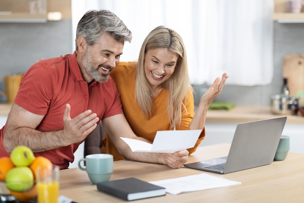 Emotional spouses reading letter from bank celebrating success