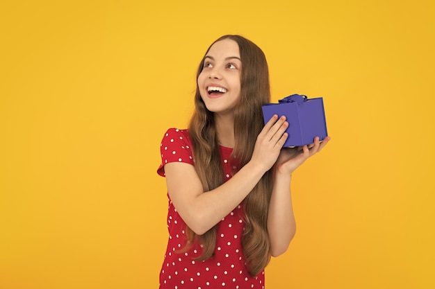 Emotional teenager child hold gift on birthday Funny kid girl holding gift boxes celebrating happy New Year or Christmas