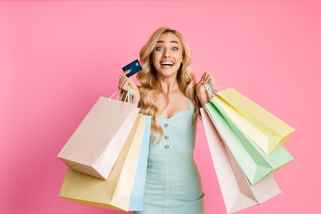 Emotional woman wearing a light blue dress and holding multiple shopping bags in her hands along