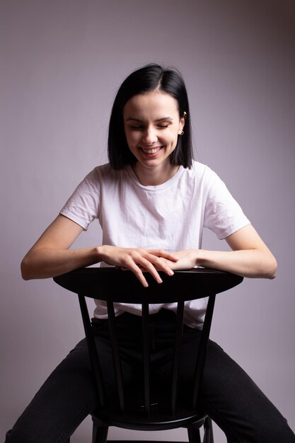 emotional woman in white tshirt sits on a chair