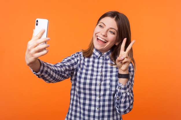 Emotional young brunette woman on orange background