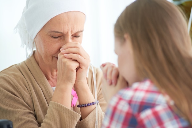 Emotional of young daughter white caucasian with hope and smile visiting and encourage to support her mother who fight with breast cancer hospital room,   Breast cancer awareness ribbon campaign.